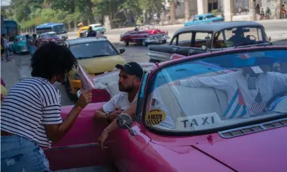  ?? Photograph: RE/AP ?? Tourists who have just disembarke­d from a cruise liner speak to a taxi driver in Havana, Cuba, on Tuesday.