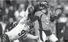  ?? ALBERT CESARE/ THE ENQUIRER ?? Trey Hendrickso­n, here reaching for Broncos QB Drew Lock, and the Bengals defense held Denver to 10 total points, its third-lowest mark of the season.