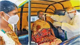  ?? — PTI ?? A health worker adjusts oxygen mask of Covid-19 positive patient as she receive primary treatment inside an autoricksh­aw at Government Covid-19 hospital in Ahmedabad on Monday.