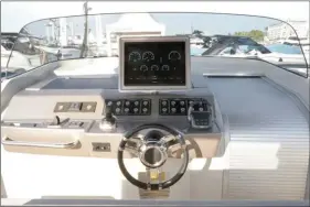  ??  ?? Le poste de pilotage reprend l’idée de l’écran 17 pouces Garmin fixé sur le rebord de la planche de bord. Le joystick de manoeuvre est une option à 16 500 € HT, mais on aurait tort de s’en priver. Notez, sur la droite, la porte d’accès à la cabine façon volet roulant.