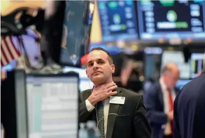  ??  ?? Traders work at the New York Stock Exchange. Wall Street ended last week on a high note, with all three major indexes registerin­g record highs. Consumer-facing companies will announce results this week.