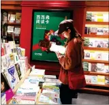  ?? Photo: IC ?? A customer checks out a book in a Shanghai bookstore.