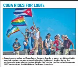  ??  ?? Supporters wave rainbow and Cuban flags in Havana on Saturday to support gay rights and to join a symbolic marriage ceremony organized by President Raul Castro’s daughter Mariela. The marchers called for equality and marriage rights for Cuba’s lesbian,...