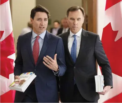  ?? ADRIAN WYLD / THE CANADIAN PRESS ?? Prime Minister Justin Trudeau walks with Finance Minister Bill Morneau to the House of Commons Tuesday, where they delivered the final budget before the writ drops for the upcoming federal election.