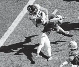  ?? CHARLIE RIEDEL AP ?? TCU quarterbac­k Max Duggan is upended by Kansas cornerback Cobee Bryant near the goal line in the first half. Duggan passed for two touchdowns and rushed for another in the Horned Frogs’ win Saturday.