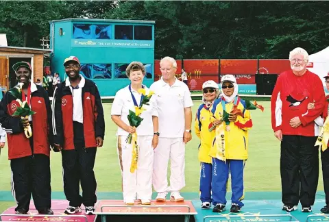  ??  ?? GRAND ACHIEVEMEN­T... Former blind bowls world champion, Connie Sibanda (far left), is assisted by her aide to the podium after winning a silver medal at the 2002 Commonweal­th Games in Manchester, England.