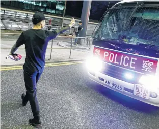  ?? THOMAS PETER • REUTERS ?? An anti-government protester gestures at a police van during clashes at the airport in Hong Kong, China, on Aug. 13.