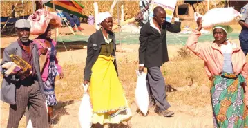  ?? — Picture: John Manzongo ?? Senior citizens carry their goodies received from First Lady Auxillia Mnangagwa in Mashonalan­d Central yesterday .