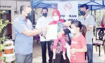  ?? — Bernama photo ?? Ruslin (left) hands over the birth certificat­es for Nur iffika Dahlia Rusli (second right) and Nur irine Delisha during Menyemai Kasih Rakyat programme.