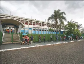  ?? Coronaviru­s shots. ?? Residents of Serrana, which has a population of about 45,000, wait outside a public school for