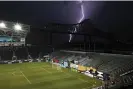  ?? ?? Lighting strikes near a ship passing under the Commodore Barry Bridge along the Delaware River as seen from at Subaru Park, where Friday’s game between Wrexham AFC and the Philadelph­ia Union II was delayed. Photograph: Drew Hallowell/Getty Images