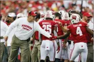  ?? ANDY MANIS — THE ASSOCIATED PRESS ?? Wisconsin head coach Paul Chryst congratula­tes wide receiver A.J. Taylor after a Wisconsin touchdown during the first half Saturday in Madison, Wis. Wisconsin won 35-14.