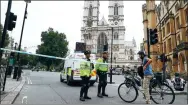  ?? HANNAH MCKAY / REUTERS ?? Police officers stand at a cordon after a car crashed outside the Houses of Parliament in London on Tuesday. It is being treated as a terrorist incident.