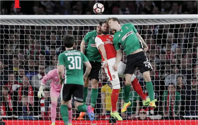  ?? — AFP ?? LONDON: Arsenal’s French striker Olivier Giroud (2nd R) is hurt in this clash with Lincoln City’s English defender Luke Waterfall and Lincoln City’s English defender Sean Raggett (R) during the English FA cup quarter final football match between Arsenal and Lincoln City at The Emirates Stadium in London yesterday.