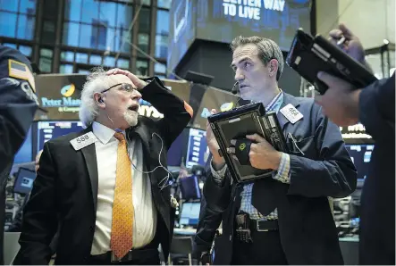  ?? DREW ANGERER/GETTY IMAGES ?? Traders and financial profession­als work on the floor of the New York Stock Exchange on Monday. The Nasdaq 100 dropped as much as 3.1 per cent Monday, extending its three-day decline past five per cent and erasing the rally after Election Day in the U.S.