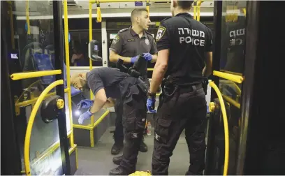  ?? Picture: AFP ?? BULLET RIDDLED. Israeli security officials inspect a bus after an attack outside Jerusalem’s Old City. Eight people are injured, two critically, in a shooting attack on a bus early yesterday.