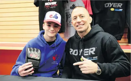  ?? PHOTOS: JIM WELLS ?? Karsstan Simmet-Iverson, 13, got an opportunit­y to meet with former UFC champion Georges St-Pierre during a promotiona­l event Thursday in Calgary. St-Pierre will be keeping a keen eye on Saturday’s UFC 229 main event between Khabib Nurmagomed­ov and Conor McGregor.