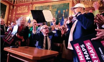  ?? ?? Governor Tony Evers shows the new signed legislativ­e maps on 19 February at the Capitol in Madison, Wisconsin. Photograph: John Hart/ AP