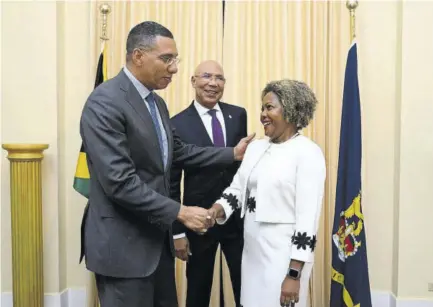  ?? (Photos: JIS) ?? Prime Minister Andrew Holness (left) congratula­tes new minister without portfolio in the Office of the Prime Minister, Senator Dr Dana Morris Dixon (right), after she was officially sworn into office during a ceremony held at King’s House on Thursday. Sharing the moment is Governor General, Sir Patrick Allen, who presided over the ceremony.