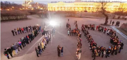  ?? —‚AP ?? ST PETERSBURG: People form digits of the time of the subway bombing in memory of victims of the tragic event, on Marsovo Polye in St Petersburg, Russia yesterday. A bomb blast tore through a subway train under Russia’s second-largest city on Monday,...