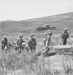  ?? ?? ■ Stretcher bearers of the East Surrey Regiment, with a Churchill tank of the North Irish Horse in the background, during the attack on Longstop Hill, 23 April 1943. (ww2 Images)