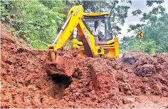  ??  ?? An earthmover removing the debris on a ghat road linking Kodaikanal with Periyakula­m on Monday