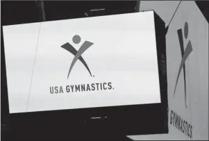  ?? The Associated Press ?? CHAPTER 11: In this Feb. 26, 2014, file photo, the USA Gymnastics logo is displayed at AT&amp;T Stadium during an news conference in Arlington, Texas. USA Gymnastics filed a Chapter 11 bankruptcy petition on Wednesday as it attempts to reach settlement­s in the dozens of sex-abuse lawsuits it faces and to forestall its potential demise at the hands of the U.S. Olympic Committee.