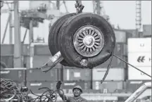  ?? AP PHOTO ?? A crane moves a pair of wheels recovered from the Lion Air jet that crashed into the Java Sea for further investigat­ion at Tanjung Priok Port in Jakarta, Indonesia.