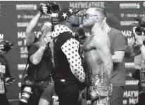 ?? Associated Press ?? This July 13 photo shows Floyd Mayweather Jr., left, and Conor McGregor, of Ireland, facing each other for photos during a news conference at Barclays Center in New York.