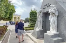  ?? ?? Tourists walk past graves at Colon Cemetery in Havana.