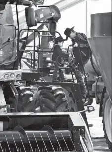  ?? Herald photo by Ian Martens ?? Warren Many Grey Horses and his grandson Sootah climb down from a combine on display along machinery row during Ag Expo at Exhibition Park. Ag Expo and the North American Seed Fair wrapped up Friday. @IMartensHe­rald