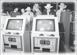  ?? Calgary Herald Archive ?? Officials examined new video lottery machines that were brought in July 4, 1991, to be used in the Frontier Casino at Stampede Park.