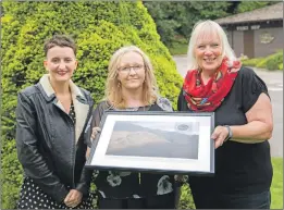  ?? Photograph: Abrightsid­e Photograph­y. ?? Friends of Nevis trustees Claire MacLeod and Fiona McSorland present a plaque to BNHC manager Yvonne Ross outside the centre last week.