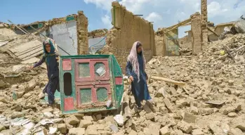  ?? AHMAD SAHEL ARMAN/GETTY-AFP ?? Earthquake fallout: Afghan men comb the ruins of a damaged house for their belongings Thursday in Paktika province, the epicenter of Wednesday’s magnitude 6.0 temblor. State media reported that at least 1,000 people died, but U.N estimates gave a lower death toll, saying around 770 people had been killed in Paktika and Khost provinces.