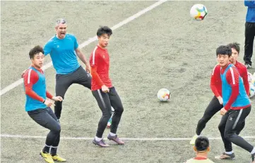  ??  ?? File photo of Beijing Institute of Technology’s Spanish head coach Roberto Ahufinger del Pino (second left) taking part in a football training session with his players in Beijing. — AFP photo