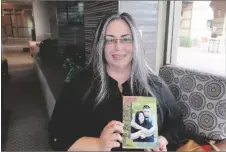  ?? AP PHOTO/FELICIA FONSECA ?? Carmen Briones holds a photo of her and her husband, Riley Briones Jr., on Feb. 22 in Anthem, Arizona.