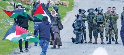  ??  ?? ↑
Palestinia­ns clash with Israeli troops in the Jordan Valley area of West Bank on Tuesday.
Agence France-persse