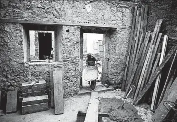  ?? EDUARDO VERDUGO/AP ?? A mason pulls a wheelbarro­w inside 25 Manzanares Street, in Mexico City, possibly the oldest house in North America.