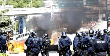  ??  ?? Riot police respond to demonstrat­ors setting a road block on fire during the G7 Summit in Quebec City, Quebec, Canada. — Reuters photo