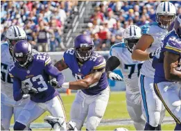  ??  ?? Minnesota running back Adrian Peterson is stopped by Tennessee strong safety Da’Norris Searcy during the second half of Sunday’s game.