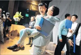  ?? Christina House
For The Times ?? DUAN RONGFENG hoists his new husband, Li Tao, after the contest-winning Shanghai couple got married at West Hollywood Library.