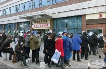  ?? ASSOCIATED PRESS ?? In this Friday, Jan. 31, photo, people wearing surgical masks line up outside a fever clinic at Wuhan Union Hospital in Wuhan in central China’s Hubei Province. The United States on Friday declared a public health emergency and took drastic steps to significan­tly restrict entry into the country because of a new virus that hit China and has spread to other nations.