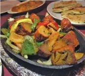  ??  ?? The lamb and other meat dishes are served fajita-style at Purnima Bangladesh­i Cuisine. (Photo by Cliff Bostock)