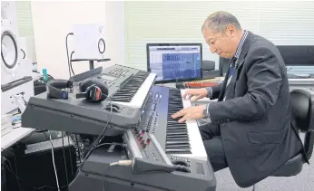  ??  ?? MIND THE GAP: Japanese musician Minoru Mukaiya playing electronic music on a piano at his workplace in Tokyo. Mukaiya composes short jingles that whisk commuters on their way.
