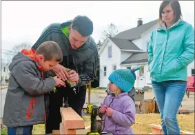  ??  ?? Above, Colton helps Josh use a drill as Hadley and Kelsey watch on March 27 while building a saw horse at their home in Groton.