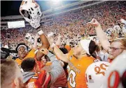  ?? [PHOTO BY SARAH PHIPPS, THE OKLAHOMAN] ?? Oklahoma State players celebrate a win over Texas with fans who rushed the Boone Pickens Stadium field on Saturday night.