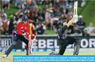  ?? —- AFP ?? HAMILTON: New Zealand’s Martin Guptill (R) is bowled out as England’s wicketkeep­er Jos Buttler (L) looks on during the Twenty20 Tri Series internatio­nal cricket match between New Zealand and England at Seddon Park in Hamilton yesterday.