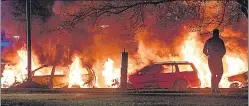  ?? ?? A protester stands near burning cars in Malmo, Sweden on Sunday.