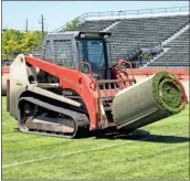  ?? Photos by Doug Walker ?? Below: Deluxe Grading crews roll up and remove the old artificial surface at Barron Stadium Monday.