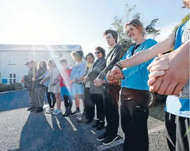  ?? Photo: MARTIN DE RUYTER/FAIRFAX NZ ?? Protesters calling for the use of cannabis oil in treating Nelson teenager Alex Renton join hands outside the offices of Nelson MP Nick Smith.